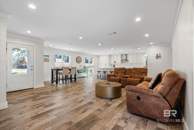 living room with crown molding and light hardwood / wood-style floors