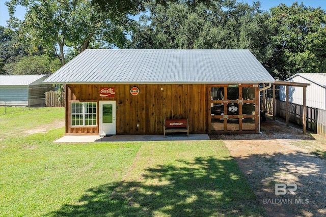 exterior space featuring a lawn and an outbuilding