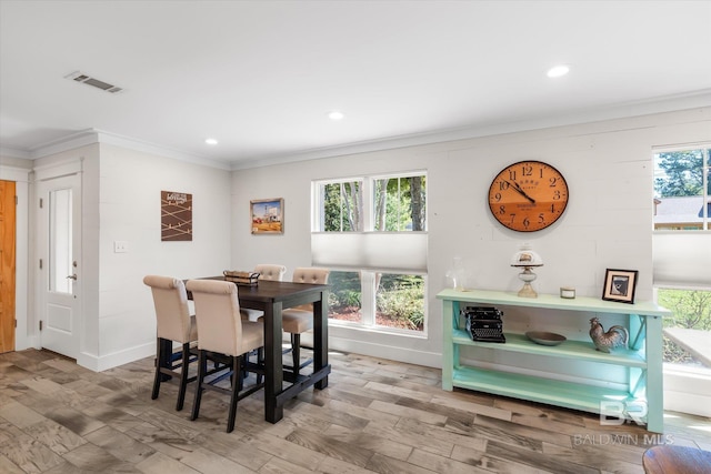 dining space with ornamental molding, hardwood / wood-style floors, and a healthy amount of sunlight