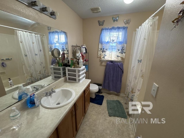 bathroom with curtained shower, a textured ceiling, tile patterned flooring, vanity, and toilet