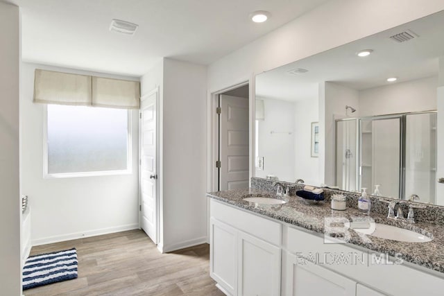 bathroom with vanity, hardwood / wood-style flooring, and a shower with shower door