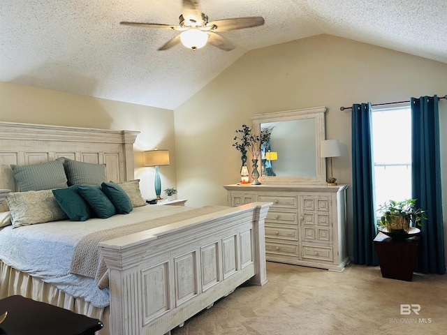 bedroom featuring lofted ceiling, a ceiling fan, a textured ceiling, and light colored carpet