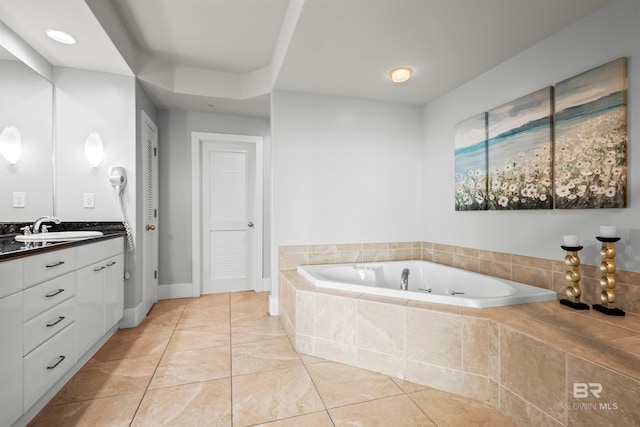 bathroom with tile patterned flooring, vanity, and tiled tub