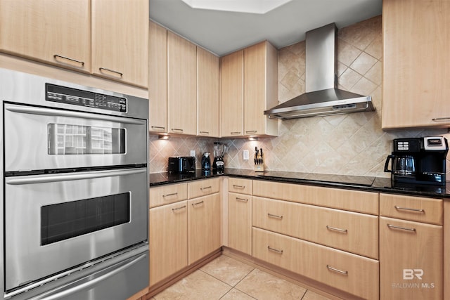 kitchen with light brown cabinets, wall chimney range hood, double oven, black electric cooktop, and light tile patterned flooring