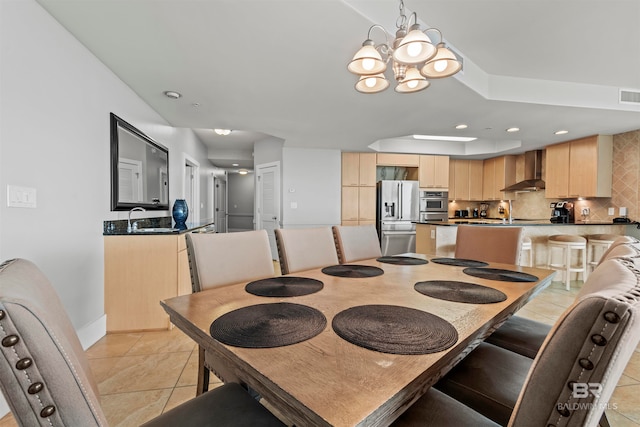 tiled dining space with sink and an inviting chandelier