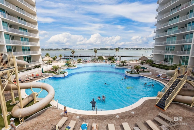 view of swimming pool with a patio and a water view