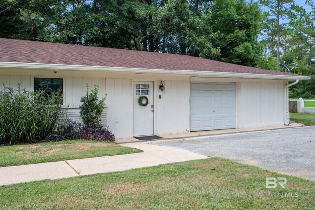 ranch-style home featuring a front lawn and a garage