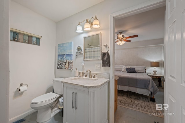 bathroom with baseboards, ceiling fan, toilet, tile patterned floors, and vanity