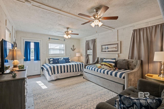 bedroom with a textured ceiling, ornamental molding, and ceiling fan