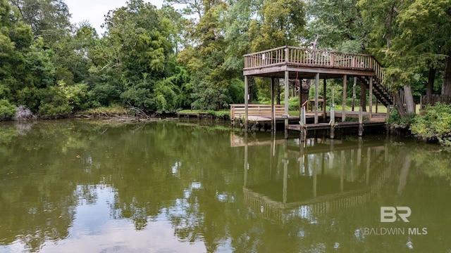 view of dock with a deck with water view, a view of trees, and stairway