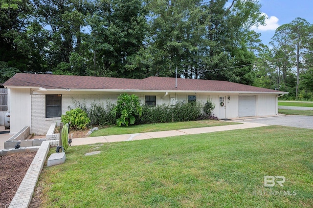 ranch-style home featuring brick siding, an attached garage, driveway, and a front yard