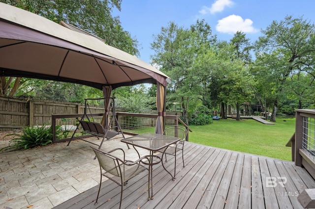 wooden terrace with a gazebo and a yard