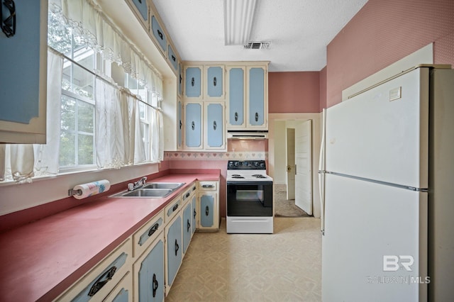 kitchen featuring white appliances, backsplash, sink, and a textured ceiling