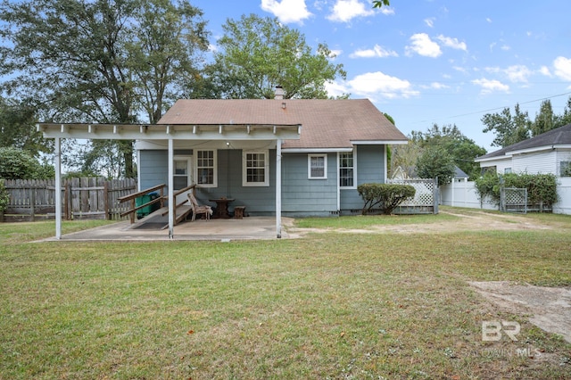 rear view of house with a yard and a patio