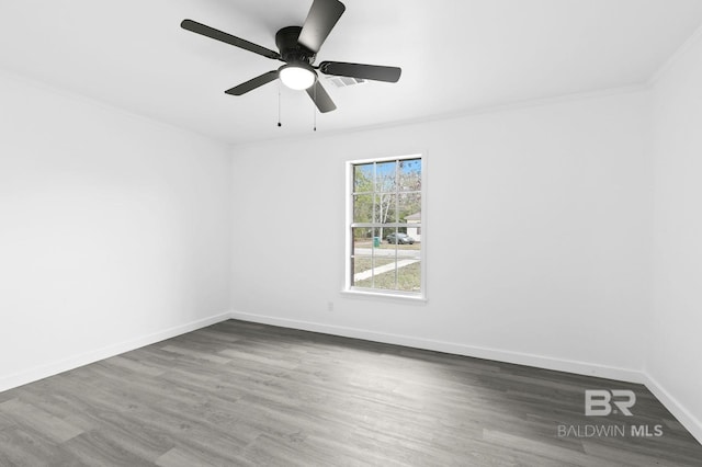 unfurnished room with ceiling fan, dark wood-type flooring, and crown molding