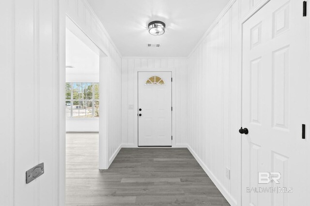 entryway featuring wooden walls, dark hardwood / wood-style flooring, and crown molding