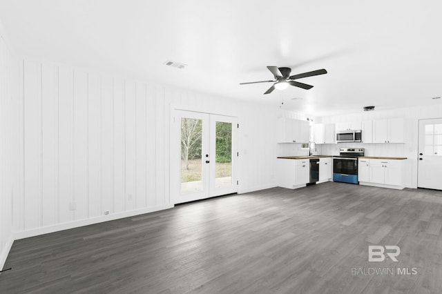 unfurnished living room featuring sink, french doors, dark hardwood / wood-style flooring, and ceiling fan