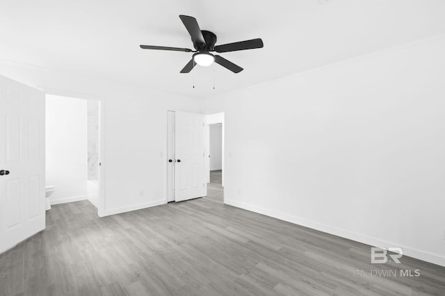 unfurnished bedroom featuring crown molding, connected bathroom, ceiling fan, and light wood-type flooring