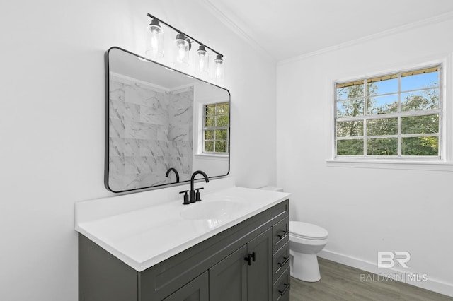 bathroom with toilet, vanity, ornamental molding, and hardwood / wood-style flooring