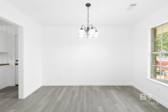 empty room with an inviting chandelier and light hardwood / wood-style floors