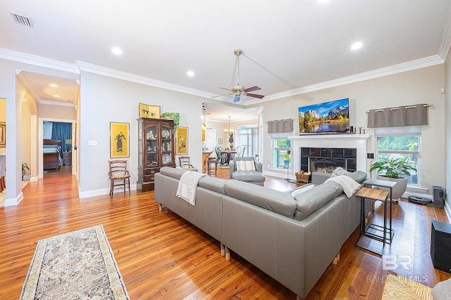 living room with light hardwood / wood-style floors, plenty of natural light, ceiling fan, and a tile fireplace