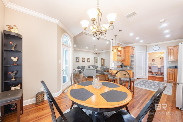 dining area featuring crown molding, ceiling fan with notable chandelier, and light wood-type flooring