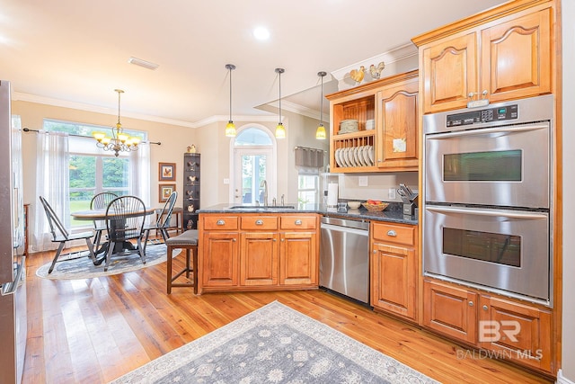 kitchen featuring light hardwood / wood-style flooring, decorative light fixtures, appliances with stainless steel finishes, a chandelier, and sink