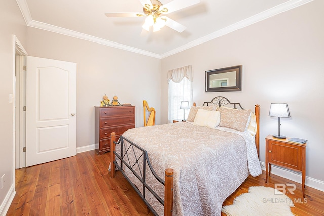 bedroom featuring hardwood / wood-style floors, ceiling fan, and crown molding