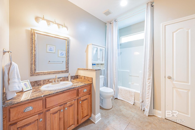 bathroom with vanity, toilet, tile patterned floors, and walk in shower