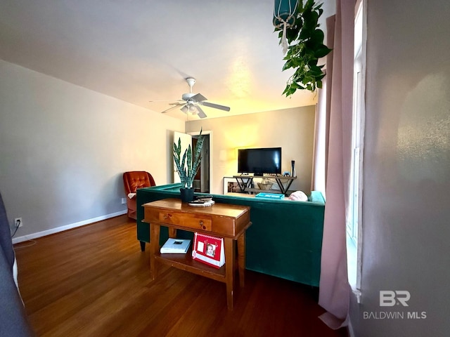 living room featuring dark wood-type flooring and ceiling fan