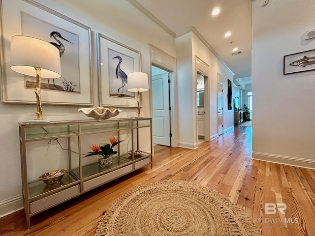 hall with crown molding, recessed lighting, visible vents, wood finished floors, and baseboards