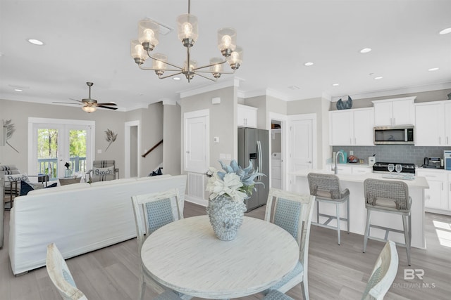 2831 Salt Dr, Orange Beach, AL 36561 - dining area with crown molding, a ceiling fan, a chandelier, light wood-style flooring, and recessed lighting