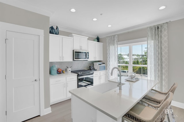 2831 Salt Dr, Orange Beach, AL 36561 - kitchen featuring gas stove, stainless steel microwave, light wood-style flooring, recessed lighting, and a sink