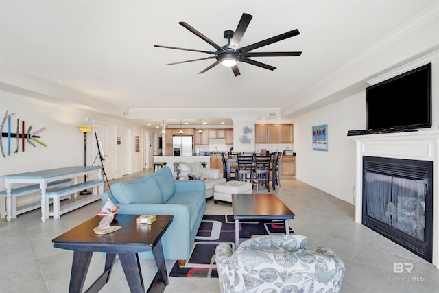 living room featuring ceiling fan, light tile patterned floors, and ornamental molding