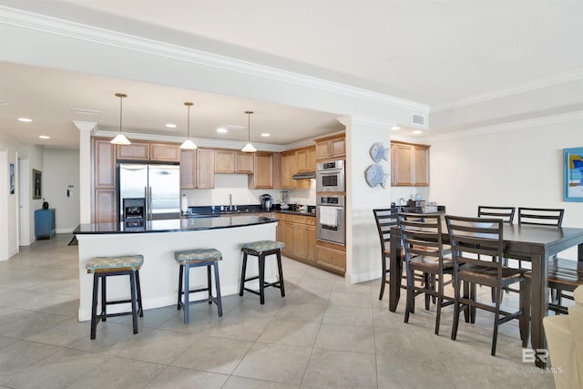 kitchen featuring hanging light fixtures, a breakfast bar, appliances with stainless steel finishes, and crown molding