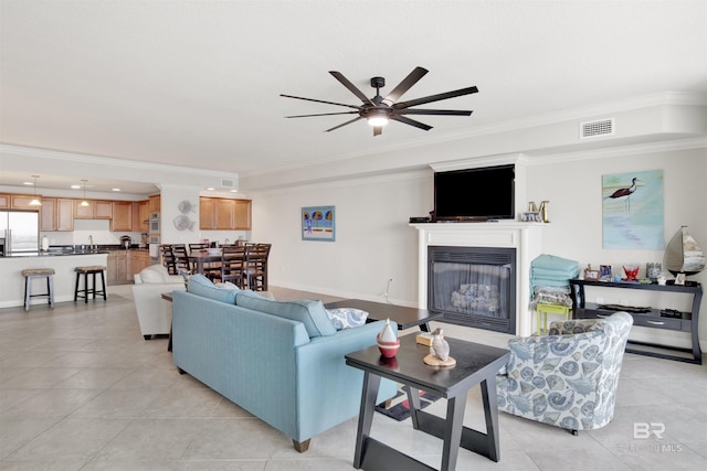 living room with light tile patterned flooring, ceiling fan, and ornamental molding