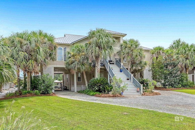 raised beach house featuring a front yard