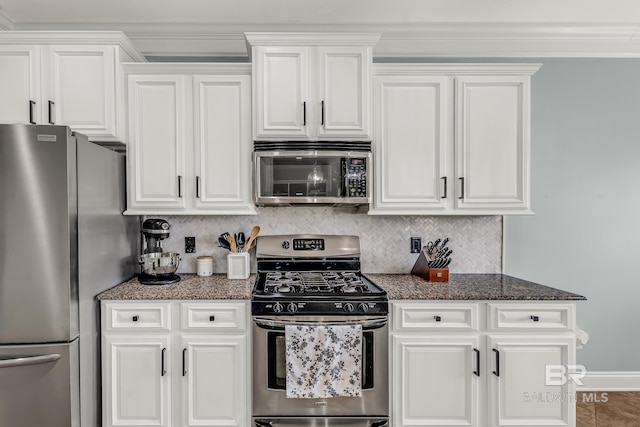 kitchen with decorative backsplash, ornamental molding, white cabinetry, dark stone countertops, and stainless steel appliances