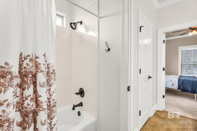 ensuite bathroom with ensuite bathroom, ornamental molding, shower / bath combo with shower curtain, and a ceiling fan