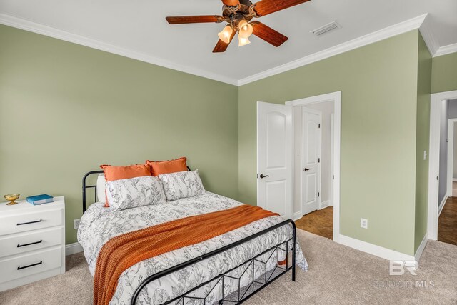 bedroom with baseboards, visible vents, ornamental molding, and light colored carpet