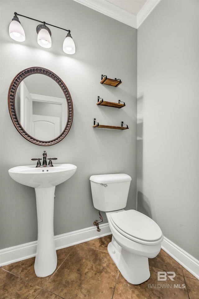 bathroom with tile patterned flooring, toilet, crown molding, and baseboards