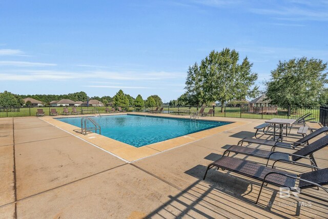 pool featuring fence and a patio