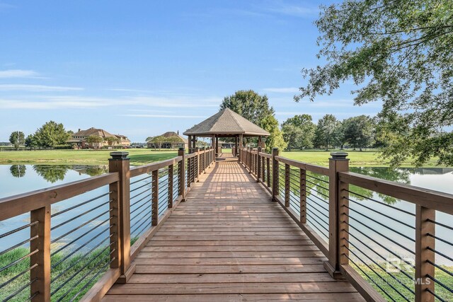 dock area featuring a water view, a yard, and a gazebo