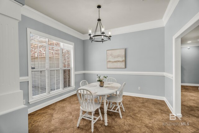 dining room with an inviting chandelier, baseboards, and ornamental molding