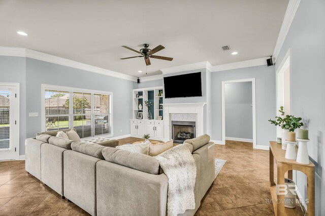 living room featuring ornamental molding, a tile fireplace, and visible vents