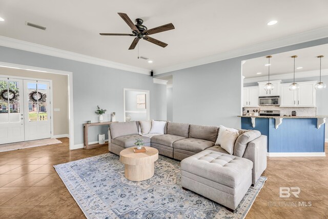 living room featuring light tile patterned floors, recessed lighting, visible vents, baseboards, and crown molding