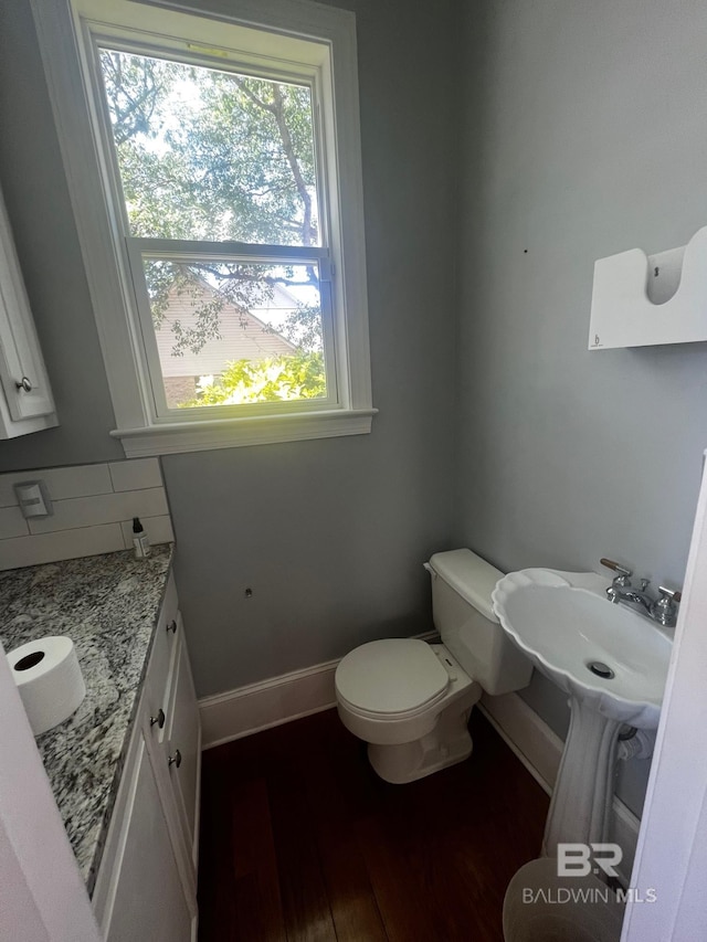 bathroom featuring a wealth of natural light, hardwood / wood-style floors, and toilet