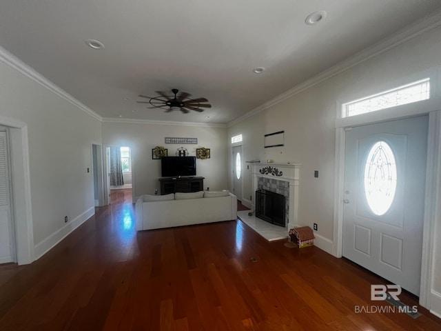 entryway with dark hardwood / wood-style floors, ceiling fan, plenty of natural light, and ornamental molding