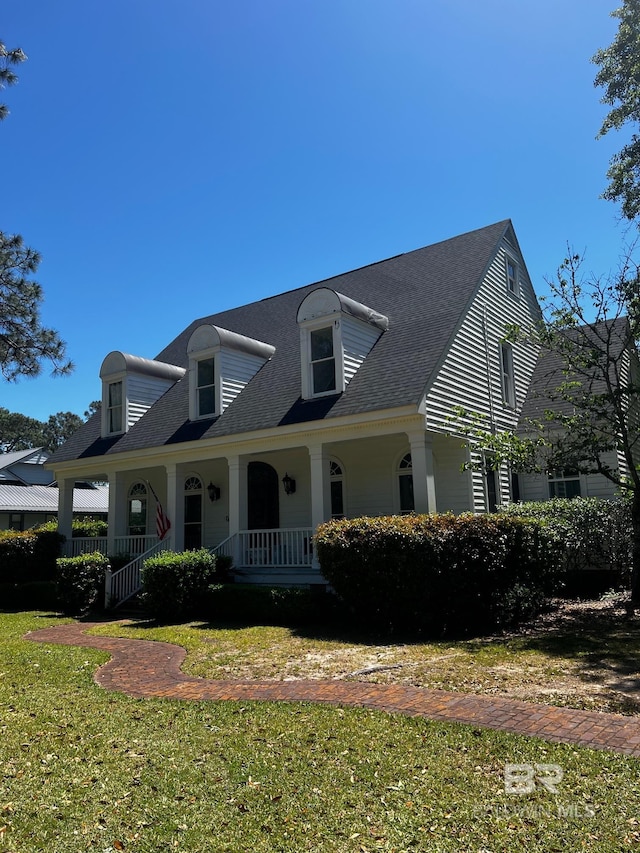 cape cod home featuring a front yard and a porch