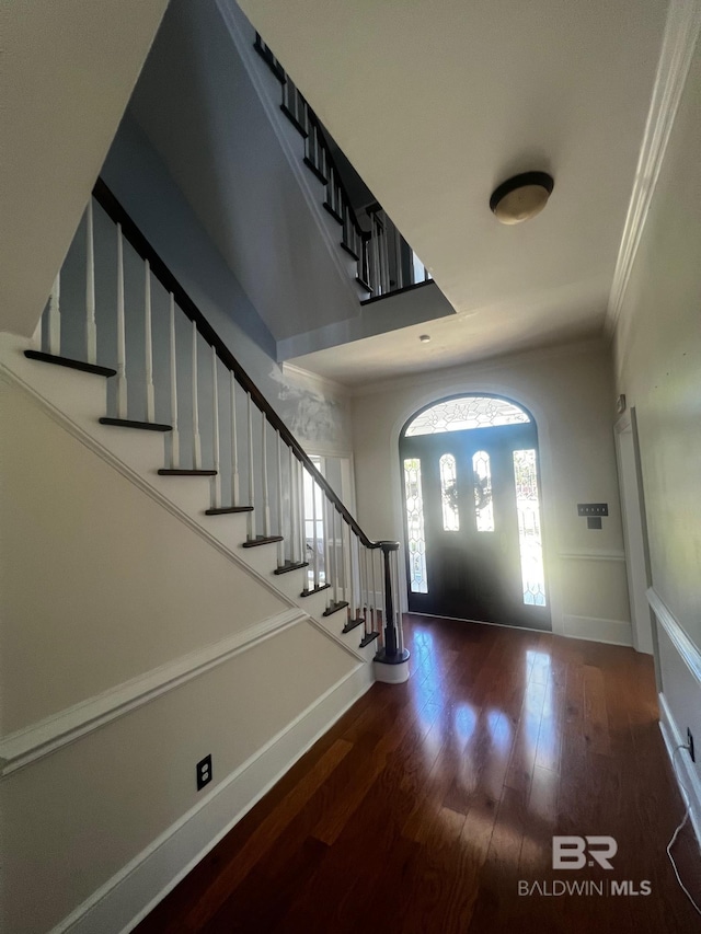 entrance foyer featuring dark wood-type flooring and ornamental molding